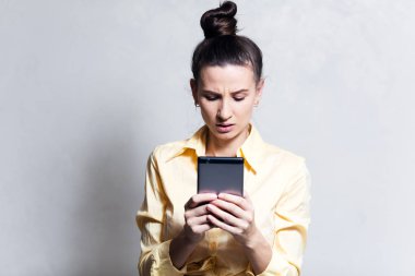 Beyaz arka plan üzerinde akıllı telefon kullanan kendine güvenen genç kız portresi