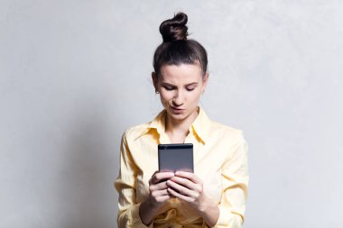 Beyaz arka plan üzerinde akıllı telefon kullanan duygusal genç kız