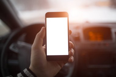 Yakın çekim, el smartphone mockup ile araba Pano arka plan üzerinde tutan adamın