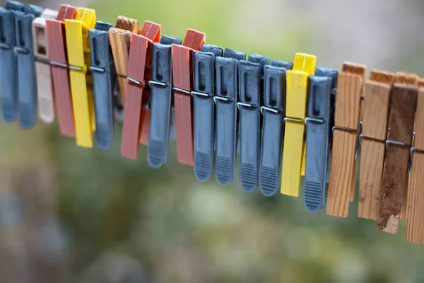 Pinces à linge colorées en plein air, sur la corde sur fond flou . — Photo