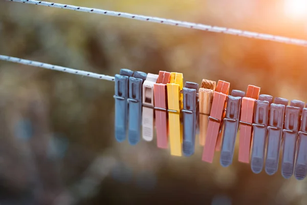 Kleurrijke wasknijpers buiten, op het touw over Blur achtergrond. — Stockfoto