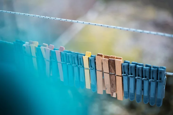 Bunte Wäscheklammern im Freien, auf dem Seil über verschwommenem Hintergrund. — Stockfoto