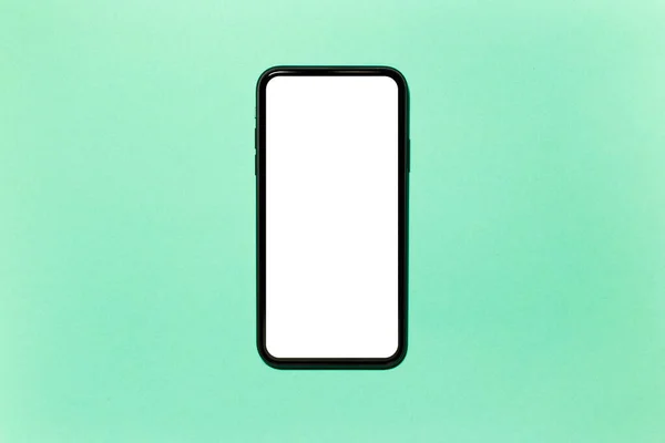 画面上の空の白いモックアップと現代のスマートフォンのトップビューのクローズアップ シアンの背景に隔離され アクアメンソールの色 — ストック写真