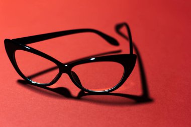 Stüdyo arka planında siyah kedi gözlüklerinin yakın plan fotokopi alanı ile koyu kırmızı rengi..