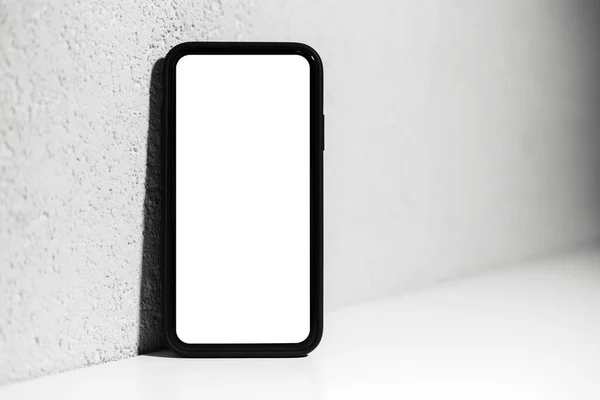 Zbliżenie Smartfona Makietą Stojącego Białym Biurku Tłem Szarej Teksturowanej Ściany — Zdjęcie stockowe