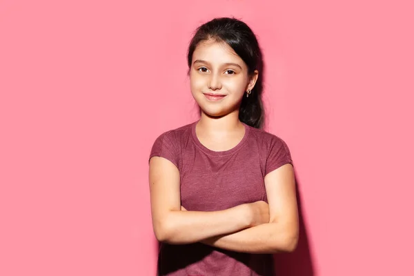 Studio Portret Uśmiechniętej Dziewczynki Krzyżowanymi Ramionami Tle Pastelowego Różowego Koloru — Zdjęcie stockowe