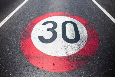 Asfalt yolda 30 km / saat hız sınırı işareti.