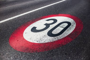 Asfalt yolda 30 km / saat hız sınırı işareti.