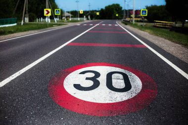 Asfalt yolda 30 km / saat hız sınırı işareti.