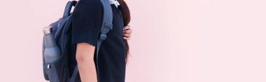 Tekrar kullanılabilir, çelik termo eko su şişesinin yakın plan resmi sırt çantasının cebinde. Pastel pembe rengin fotokopi alanı ile panoramik arkaplanı. Okul zamanı konsepti. Plastiksiz.