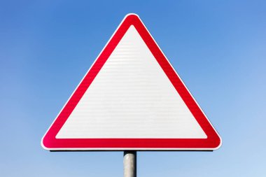 Mavi gökyüzünün arka planında boş yol işareti.