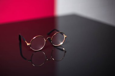 Yuvarlak gözlükleri siyah cam masaya yakın plan yap..