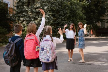 Okul bahçesinde. Aileler çocuklarını okula götürüyor.okula geri dönüyorlar.