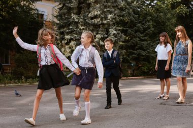 Okul bahçesinde. Aileler çocuklarını okula götürüyor.okula geri dönüyorlar.