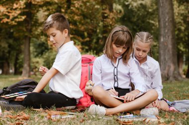 Okul çocukları doğada ödev yapıyor. Okul çocukları eğleniyor 