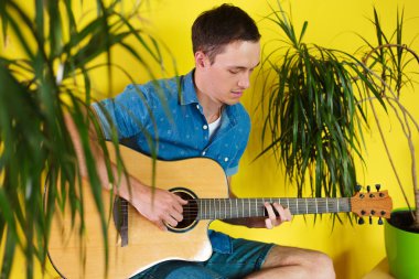 Yakışıklı ve neşeli adam müzisyen gitar çalmak bir gömlek