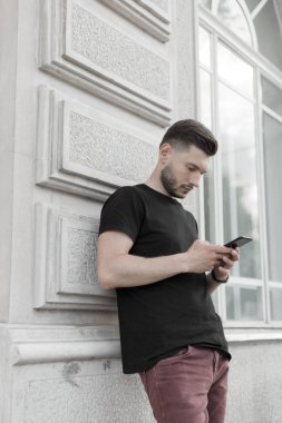 Şık giysiler içinde bir yakışıklı ve olumlu adam şehirde yürüyüş