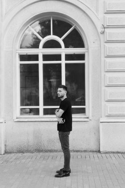 Şık giysiler içinde bir yakışıklı ve olumlu adam şehirde yürüyüş