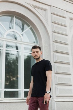 Şık giysiler içinde bir yakışıklı ve olumlu adam şehirde yürüyüş