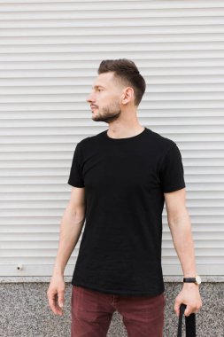 Şık giysiler içinde bir yakışıklı ve olumlu adam şehirde yürüyüş