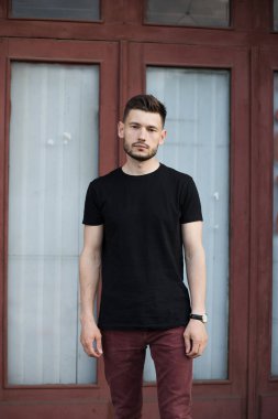 Şık giysiler içinde bir yakışıklı ve olumlu adam şehirde yürüyüş