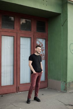 Şık giysiler içinde bir yakışıklı ve olumlu adam şehirde yürüyüş