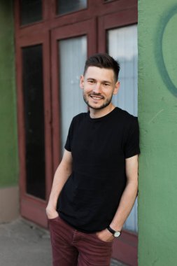 Şık giysiler içinde bir yakışıklı ve olumlu adam şehirde yürüyüş