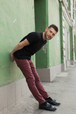 Şık giysiler içinde bir yakışıklı ve olumlu adam şehirde yürüyüş