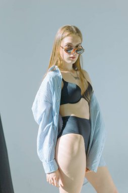 Güzel ve çekici yalın kız uzun saçlı ve gözlük beyaz bir arka plan üzerinde siyah iç çamaşırı