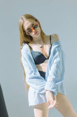 Güzel ve çekici yalın kız uzun saçlı ve gözlük beyaz bir arka plan üzerinde siyah iç çamaşırı