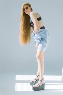 Güzel ve çekici yalın kız uzun saçlı ve gözlük beyaz bir arka plan üzerinde siyah iç çamaşırı