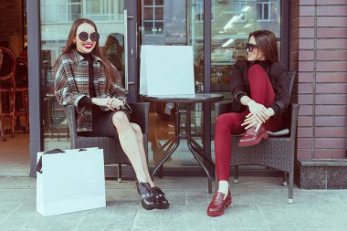 İki şık kız arkadaşım moda giysiler bir yaz gününde yürüyüş