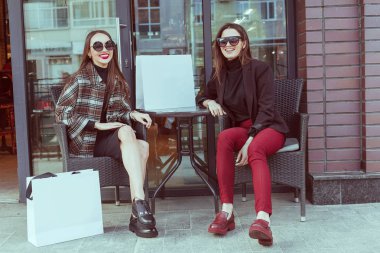 İki şık kız arkadaşım moda giysiler bir yaz gününde yürüyüş