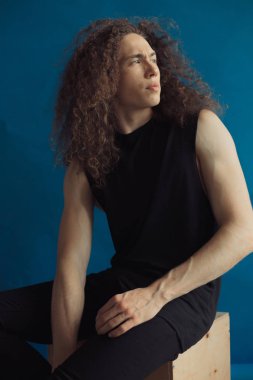 Çekici bir görünüm, kıvırcık saçlı ve şık giysiler bir adamla portreleri