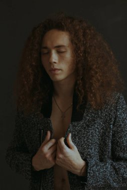 Çekici bir görünüm, kıvırcık saçlı ve şık giysiler bir adamla portreleri