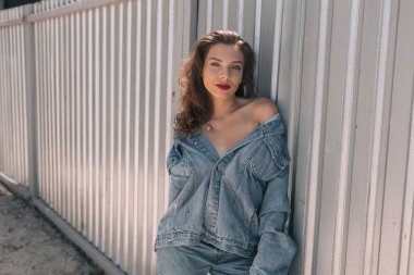 Güneşli bir yaz makyaj ile şık ve modaya uygun giysiler içinde güzel bir kız. Gülümseyen ve ciddi