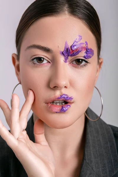 Beyaz bir arka plan üzerinde yaratıcı ve parlak makyajlı güzel duygusal kız