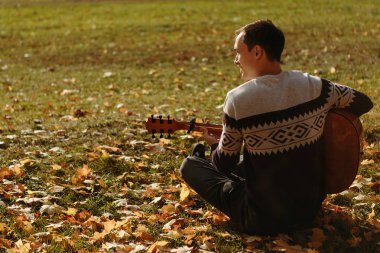 Yakışıklı olan sonbahar parkta gitar ile