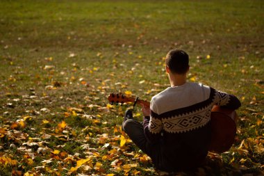 Yakışıklı olan sonbahar parkta gitar ile