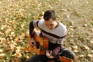 Yakışıklı olan sonbahar parkta gitar ile