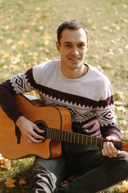 Yakışıklı olan sonbahar parkta gitar ile