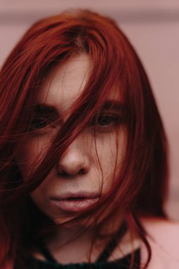 Kızıl saçlı güzel ve şık bir kız şehirde yürür ve saçları rüzgarda olduğunu