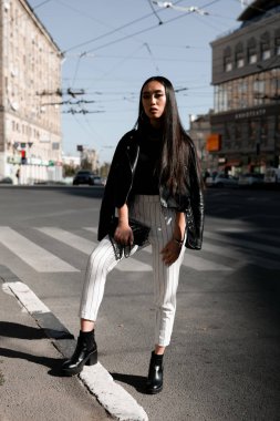 Bir kız güneşli bir şehrin sokaklarında Asya görünümünü sokak şık portresi