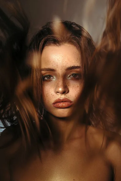 Güzellik portre makyaj, hacimli saç modeli ve küpeler ile bir güzel kız, kameraya bak