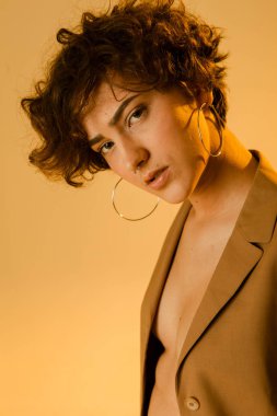 Kıvırcık saçlı, temiz cilt ve aksesuarları ile şık bir kız portresi