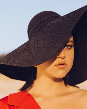 Doğada günbatımında şık giyinmiş şık bir kız. Kum, göl ve orman.