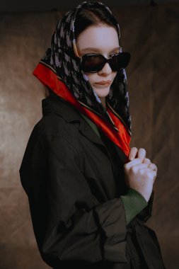 Gözlüklü bir kızın geniş portreleri ve tuvalin arka planında bir atkı.