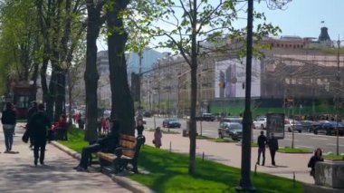 Khreshchatyk'a Caddesi. Kiev Ukrayna 20 Nisan 2018 - oturma yürüyüş insanlar. Araçlar trafik binalar yeşil çim ağaçlar yeşillik. Bahar mevsimi. Parlak güneşli bir günde. Mavi gökyüzü beyaz bulutlar 