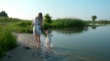 Güzel anne ile suda çalışan mutlu neşeli çocuk. Oyun ve eğlenceli olumlu duygular Nehri yakınında. Yaz Gölü sabah güneşli gün mavi gökyüzü. Yavaş hareket 30 p 0,5 60 p