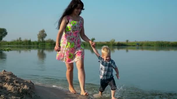 Ευτυχισμένη Χαρούμενη Παιδί Που Τρέχει Στο Νερό Την Όμορφη Μητέρα — Αρχείο Βίντεο